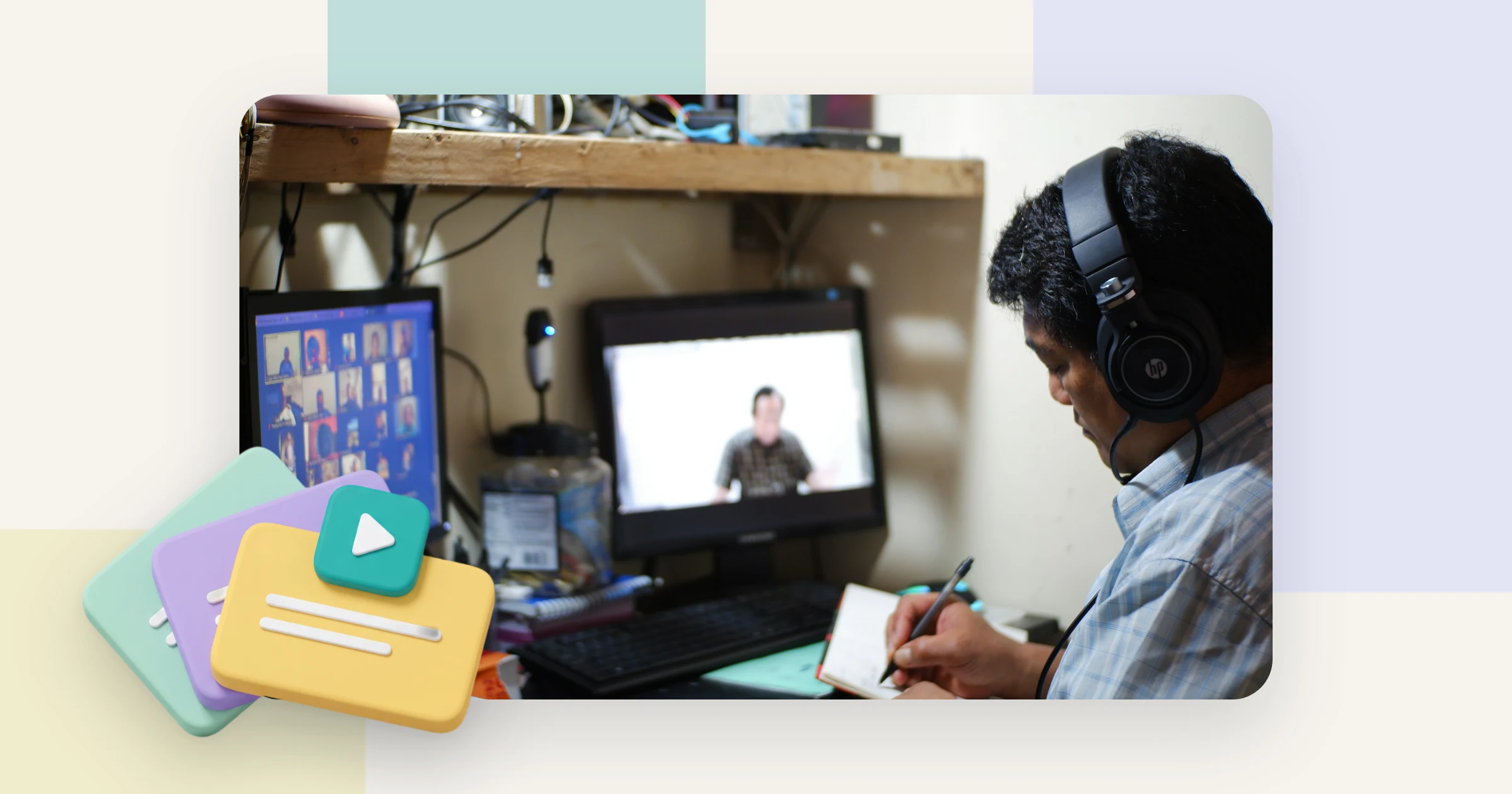 A man with headphones takes notes while he follows an instructional video on his monitor